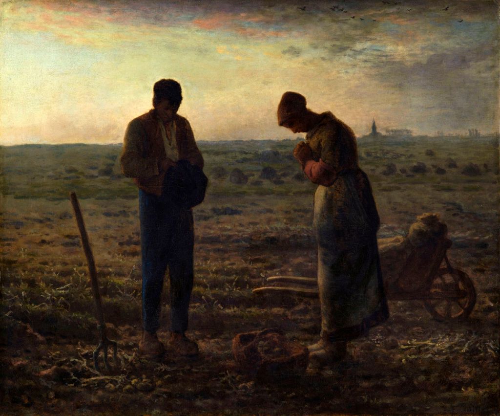 A man and a woman standing in a field at dusk, the man holding a hat and looking down while the woman stands with her hands clasped together in front of her. A pitchfork rests on the ground nearby, and a wheelbarrow can be seen behind them.